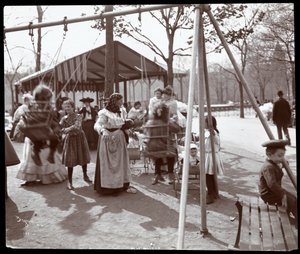 Vy över en kvinna som knuffar barn på gungorna i Tompkins Square Park, på Arbor Day, New York, 1904 (silvergelatintryck)